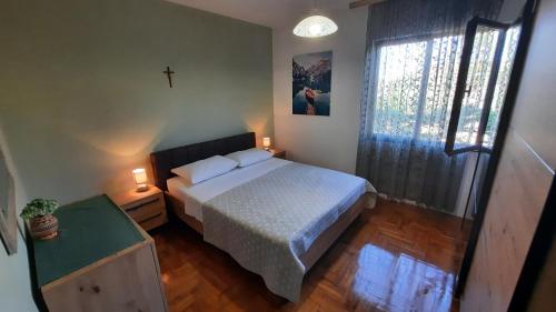 1 dormitorio con 1 cama y 1 cruz en la pared en Apartments with a parking space Kraj, Pasman - 8372 en Tkon
