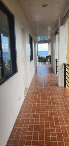 an empty hallway with a tile floor and windows at Lola's Guest House in Mactan