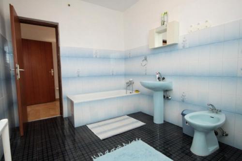 La salle de bains bleue et blanche est pourvue d'un lavabo et de toilettes. dans l'établissement Family friendly seaside apartments Nevidjane, Pasman - 8394, à Neviđane