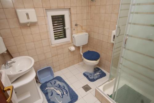 y baño con aseo, lavabo y ducha. en Apartments by the sea Kukljica, Ugljan - 8402, en Kukljica