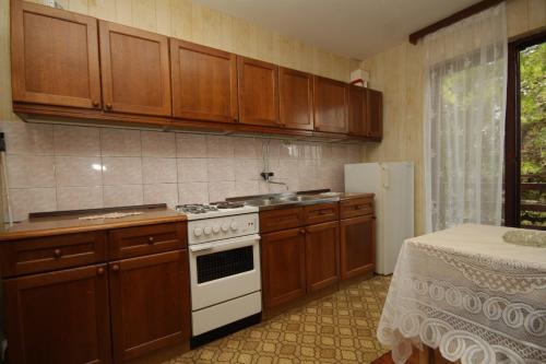 a kitchen with wooden cabinets and a stove and refrigerator at Apartments with a parking space Zdrelac, Pasman - 8514 in Ždrelac