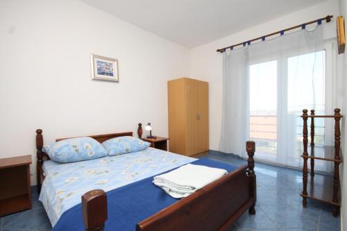 um quarto com uma cama e uma grande janela em Apartments by the sea Tkon, Pasman - 8458 em Tkon