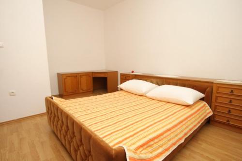 a bedroom with a bed and a wooden dresser at Apartments by the sea Mrljane, Pasman - 8463 in Neviđane