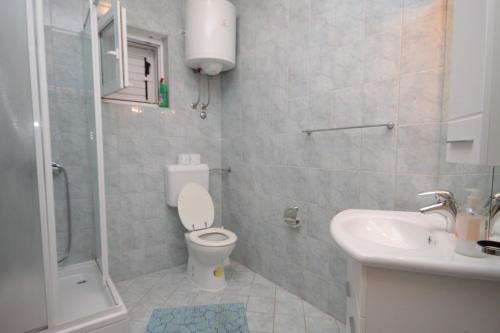 a small bathroom with a toilet and a sink at Apartments by the sea Mrljane, Pasman - 8463 in Neviđane
