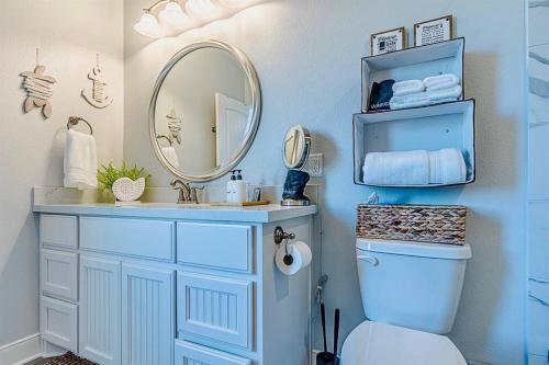 a bathroom with a sink and a mirror and a toilet at Hot tub~Amazing Views~Arcade~3 bed Luxury house in Bolivar Peninsula