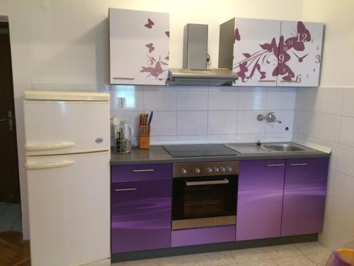 - une cuisine avec des placards violets et un réfrigérateur blanc dans l'établissement Apartments and rooms by the sea Mrljane, Pasman - 8464, à Neviđane