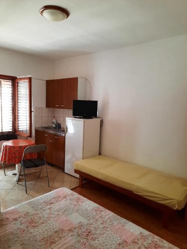 a kitchen with a bed and a refrigerator in a room at Studio Susica 8265a in Ugljan