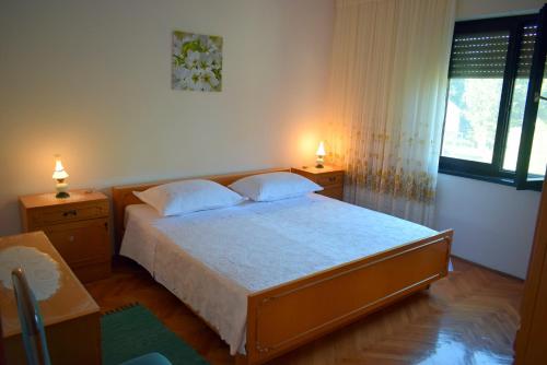 um quarto com uma cama grande e 2 candeeiros em Apartments with a parking space Ugljan - 8493 em Ugljan