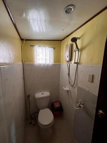 a small bathroom with a toilet and a shower at Balay Paragua in El Nido