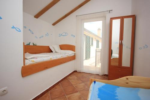 una camera da letto con un letto e uno specchio a parete di Apartment Kukljica 8209a a Kukljica (Cuclizza)