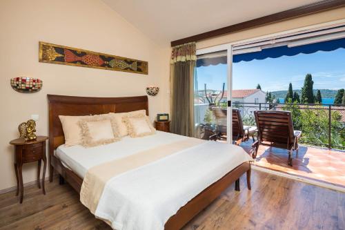 ein Schlafzimmer mit einem großen Bett und einem Balkon in der Unterkunft Seaside holiday house Okrug Gornji, Ciovo - 8645 in Trogir