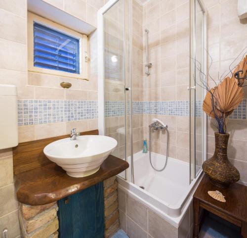 ein Bad mit einem Waschbecken und einer Dusche in der Unterkunft Seaside holiday house Okrug Gornji, Ciovo - 8645 in Trogir