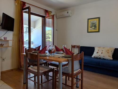 a dining room with a table and chairs and a couch at Apartments by the sea Dobropoljana, Pasman - 8198 in Dobropoljana