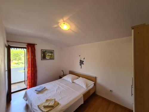 a bedroom with a bed with two towels on it at Apartments by the sea Dobropoljana, Pasman - 8198 in Dobropoljana