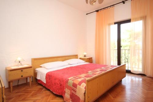 1 dormitorio con cama y ventana grande en Apartments by the sea Ugljan - 8257 en Ugljan