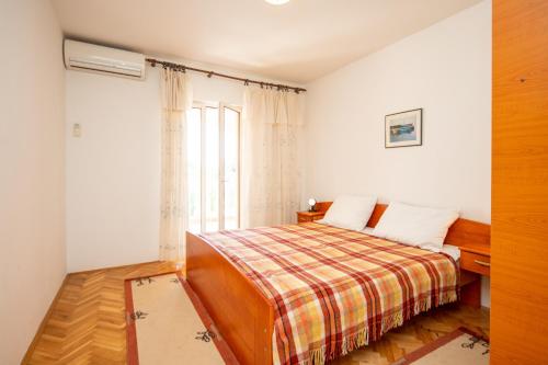 a bedroom with a bed and a window at Apartments with parking space Pasman - 8214 in Pašman
