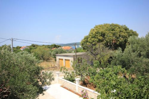 a house in the middle of some trees at Apartments with parking space Pasman - 8214 in Pašman