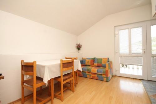 - une salle à manger avec une table et un canapé dans l'établissement Apartments by the sea Tkon, Pasman - 8227, à Tkon