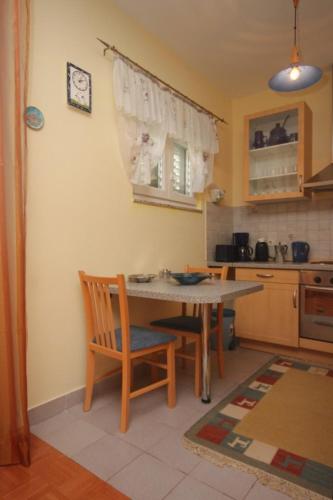 a kitchen with a table and chairs in a room at Apartment Kraj 8288a in Kraj