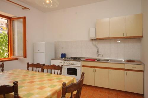 a kitchen with a table and a stove top oven at Apartments by the sea Kali, Ugljan - 8270 in Kali