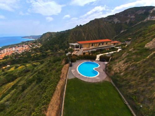 uma vista aérea de uma casa numa colina com uma piscina em Belvilla by OYO Lunedi em Parghelia