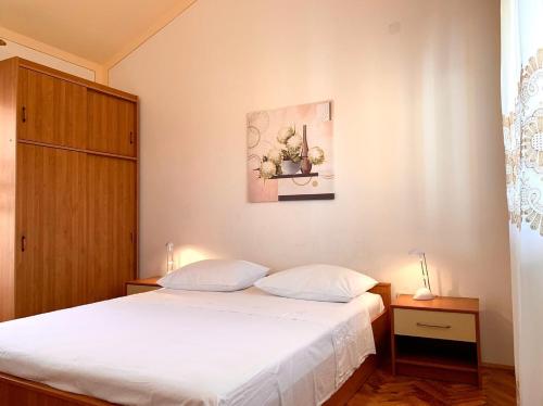 ein Schlafzimmer mit einem Bett und einem Bild an der Wand in der Unterkunft Apartments by the sea Kukljica, Ugljan - 8293 in Kukljica
