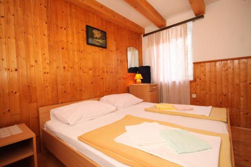 a bedroom with a bed with a wooden wall at Apartments by the sea Cavtat, Dubrovnik - 8610 in Cavtat
