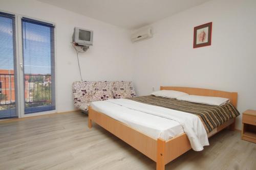 a bedroom with a bed and a chair in it at Apartments with a parking space Tribunj, Vodice - 8369 in Tribunj