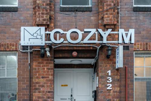 a sign for a gym on the side of a brick building at Cozy M Hostel in Sydney