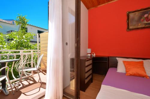a bedroom with a bed and a balcony at Apartments by the sea Arbanija, Ciovo - 8651 in Trogir