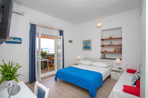 a bedroom with a bed and a table and a window at Family friendly seaside apartments Duce, Omis - 8668 in Duće