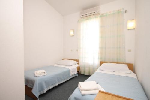 2 camas individuais num quarto com uma janela em Apartments and rooms by the sea Kukljica, Ugljan - 8408 em Kukljica