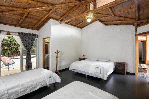 a bedroom with two beds and a patio at Rionegro Ecolodge in Tobia