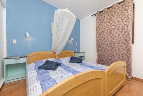 1 dormitorio con 1 cama en una habitación con paredes azules en Apartments by the sea Rastici, Ciovo - 8619 en Trogir