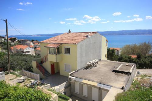 uma casa com um telhado com vista para a água em Apartments by the sea Duce, Omis - 8680 em Duće