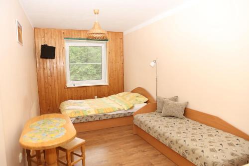 a bedroom with two beds and a chair and a window at Sea&Sand apartments in Juodkrantė