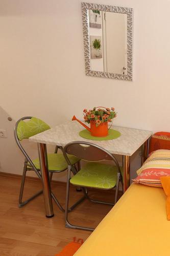 a table and chairs with a potted plant on it at Apartments by the sea Pag - 6475 in Pag