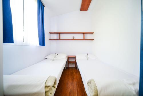 2 Betten in einem Zimmer mit 2 Fenstern in der Unterkunft Family friendly apartments with a swimming pool Biograd na Moru, Biograd - 8371 in Biograd na Moru