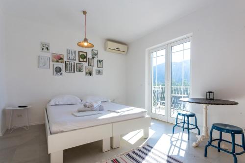Dormitorio blanco con cama y mesa en Apartments and rooms by the sea Slano, Dubrovnik - 8737, en Slano