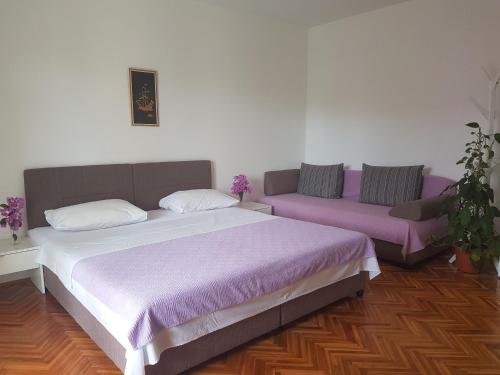 a bedroom with a large bed and a couch at Apartments by the sea Slano, Dubrovnik - 8599 in Slano