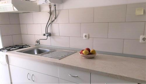 eine Küche mit einem Waschbecken und einer Schale mit Obst auf der Theke in der Unterkunft Studio Slano 8599a in Slano
