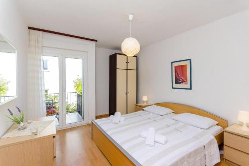 ein Schlafzimmer mit einem großen Bett und einem großen Fenster in der Unterkunft Apartments with a parking space Stari Grad, Hvar - 8708 in Stari Grad