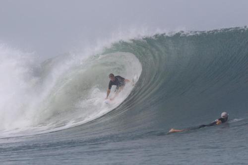 um homem a surfar uma onda numa prancha de surf no oceano em Sirena Surf Lodge Miramar Nicaragua em Miramar