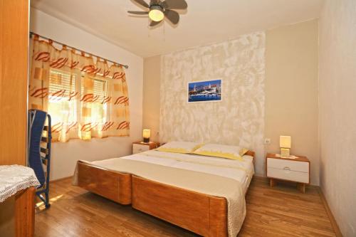 Schlafzimmer mit einem Bett und einem Deckenventilator in der Unterkunft Apartments by the sea Cove Zarace - Dubovica, Hvar - 8778 in Zarače