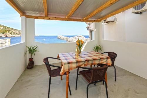 einen Tisch und Stühle auf einem Balkon mit Meerblick in der Unterkunft Apartments by the sea Cove Zarace - Dubovica, Hvar - 8778 in Zarače