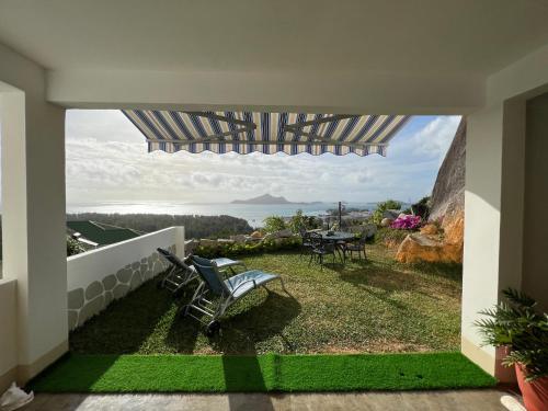 a patio with a view of the ocean from a house at Creole Pearl Self-Catering in Victoria