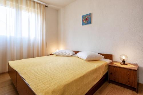 een slaapkamer met een bed met 2 kussens en een raam bij Apartments with a parking space Stari Grad, Hvar - 8697 in Stari Grad