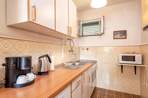 een kleine keuken met een wastafel en een magnetron bij Apartments with a parking space Stari Grad, Hvar - 8697 in Stari Grad