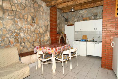a kitchen with a table and chairs and a stone wall at Seaside secluded apartments Cove Pobij, Hvar - 8702 in Gdinj
