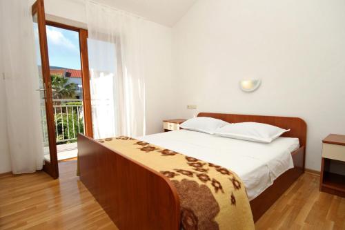 sypialnia z łóżkiem i dużym oknem w obiekcie Apartments with a parking space Jelsa, Hvar - 8765 w mieście Jelsa